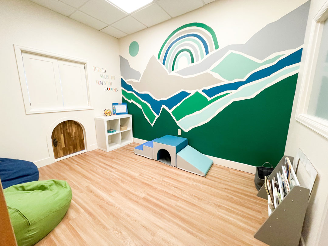 playroom in Novera physical therapy office with play items and mountain wall decal