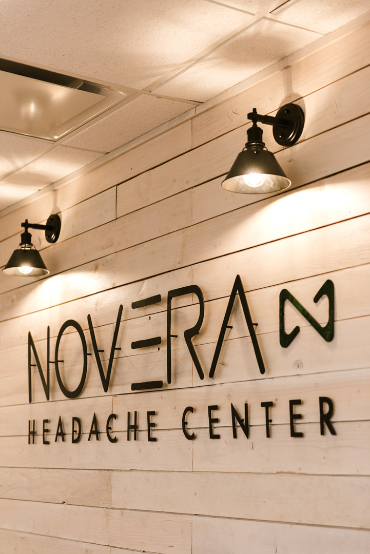 wooden wall with Novera Headache Center wall decal and industrial lights