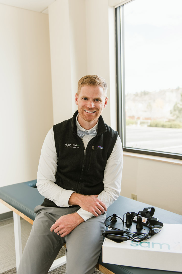 Dr. Jono Taves with SAM device sitting on physical therapy table