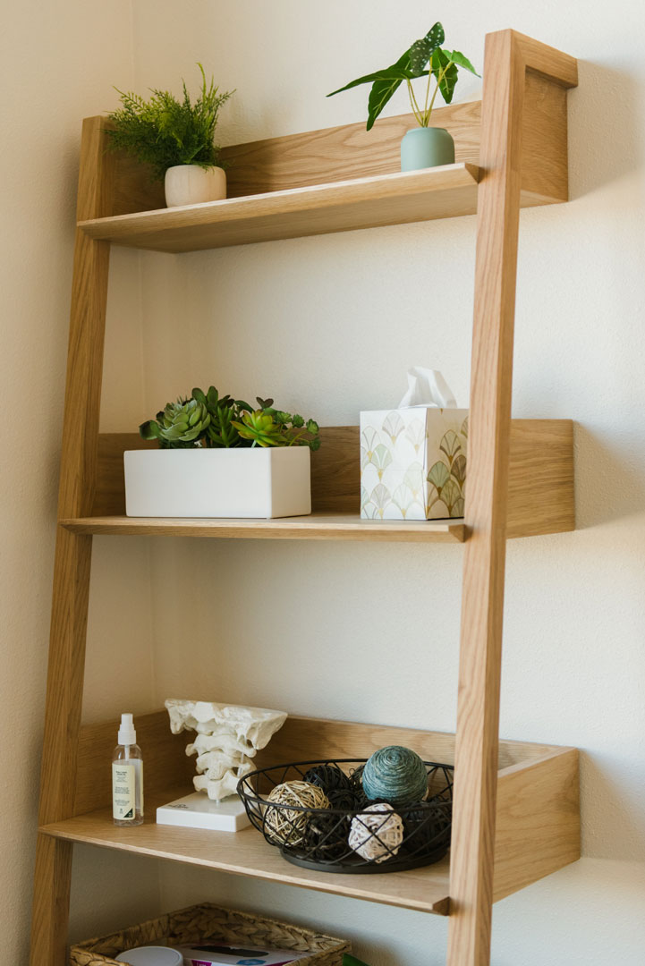 wooden shelf ladder in physical therapy office with green plants and decorations